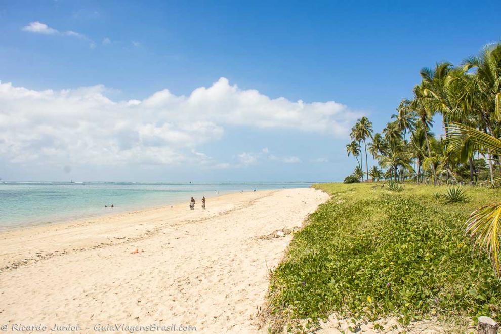 Imagem de duas pessoas caminhando pelas areias da Ilha de Itaparica.